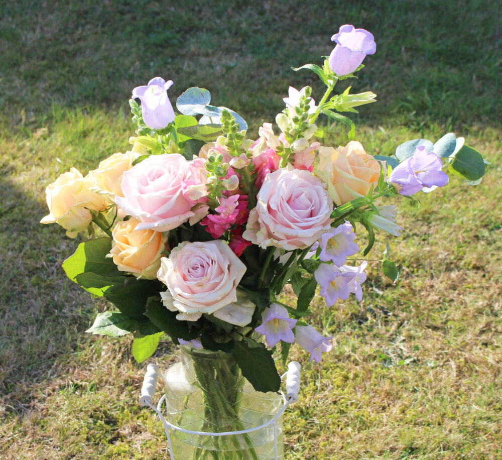The Freja from LOV Flowers Peach Avalanche Roses, Pink Sweet Avalanche Roses, lavender campanulas, pink snapdragons and fragrant eucalyptus