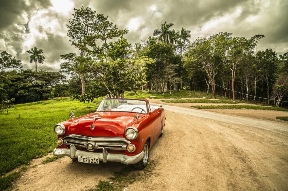 red car driving down a road