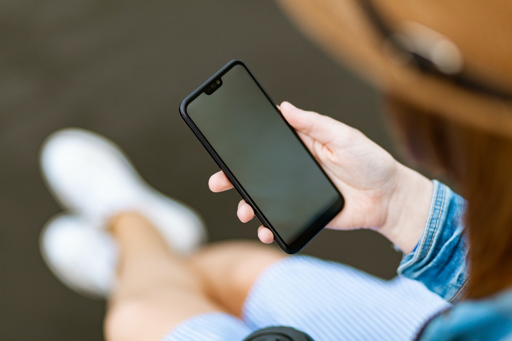Person holding a black mobile phone