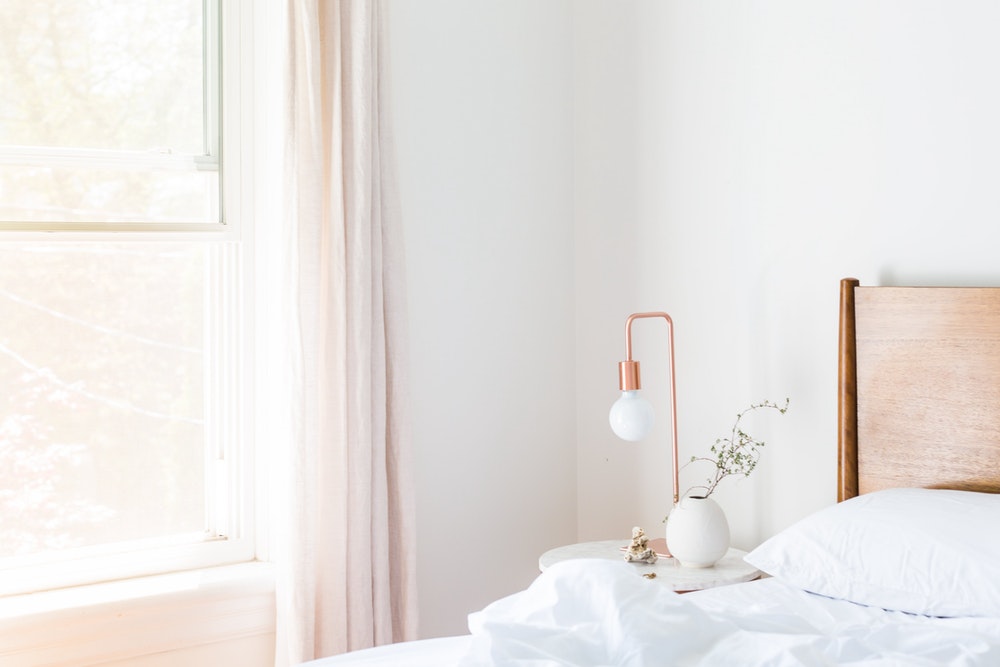 White table lamp and vase on bedside table