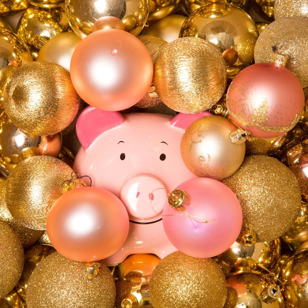pink piggy bank hidden between gold and rose gold christmas baubles