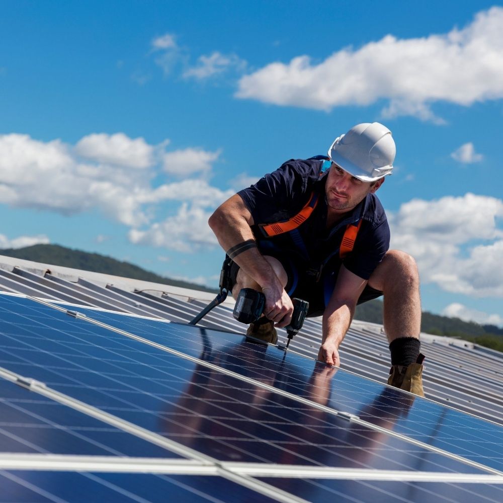 solar panel installer putting up panels with a drill