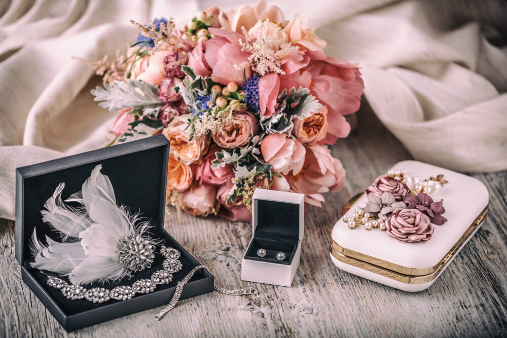 Wedding composition. Bride accessories earrings, flower, handbag, necklace