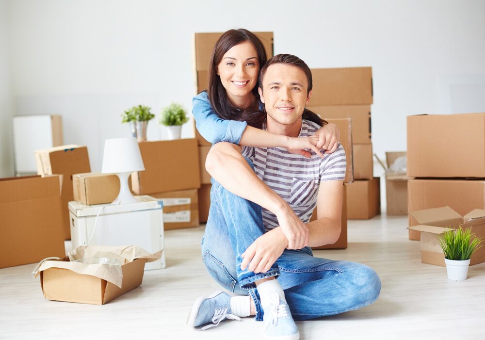 two people sat in front of packed boxes