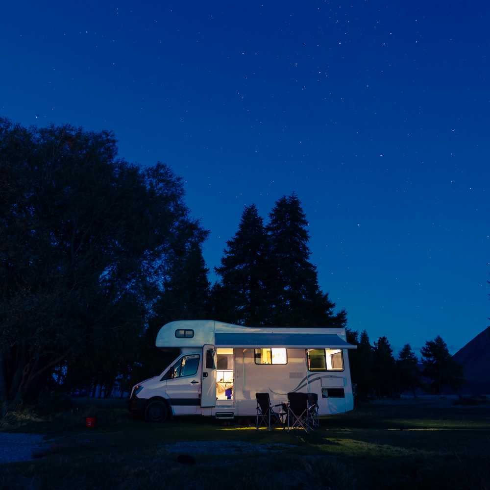 motorhome in a campsight at night with lights on