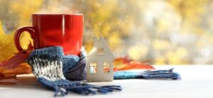 red cup wrapped in a blue scarf next to a small white house