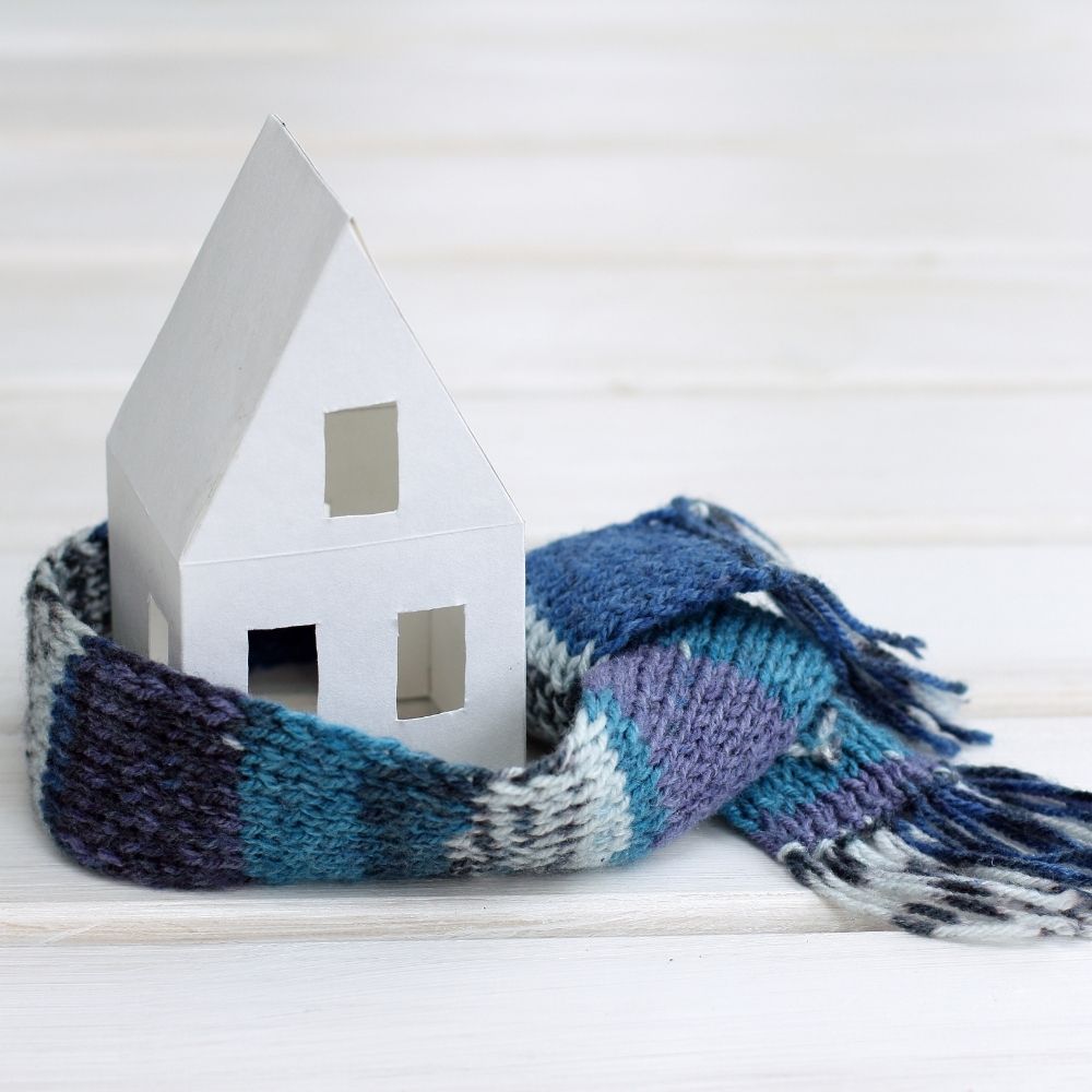 small model of a house in white wrapped with a blue scarf