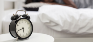 alarm clock with a person sleeping in the background