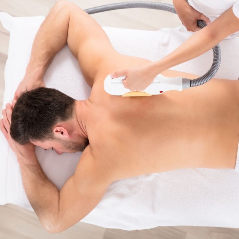 man having hair removal treatment on his back