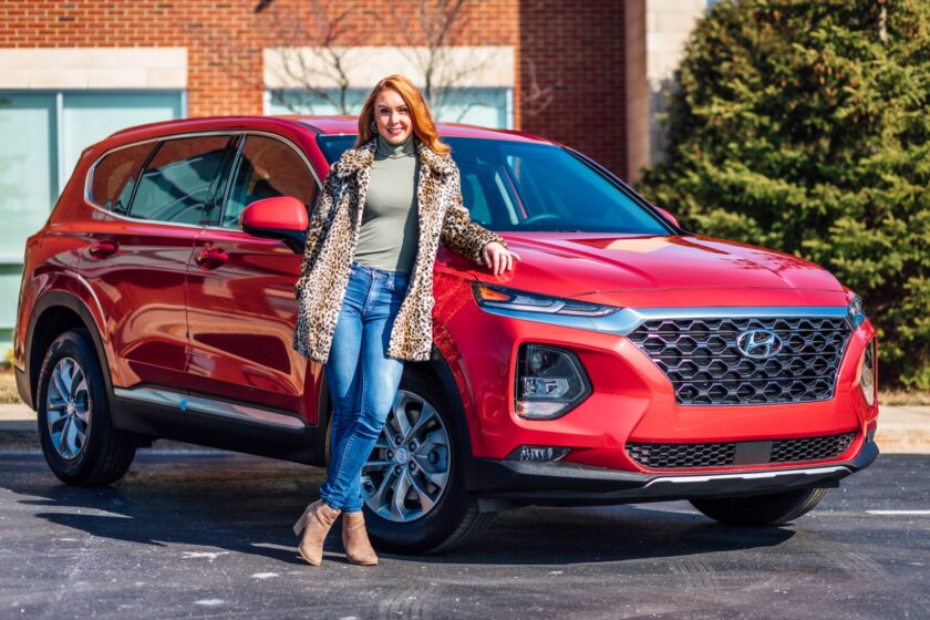 woman stood by a red car