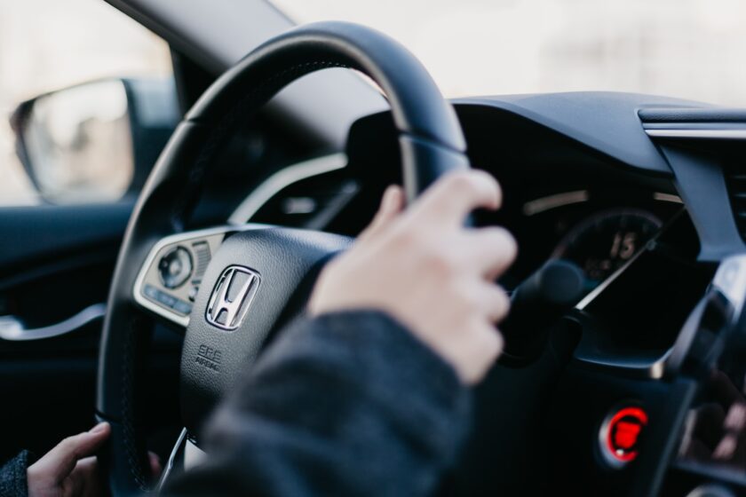 persons hands on a car steering wheel
