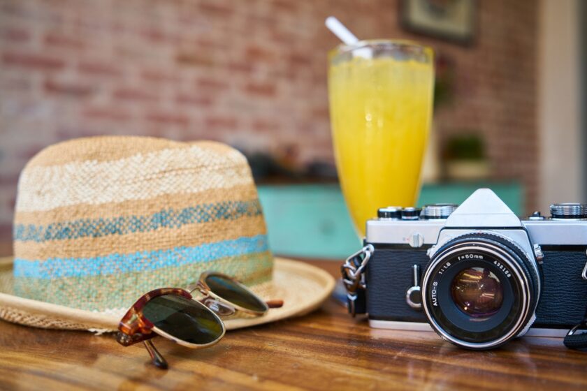 Holiday vibes with a hat sunglasses cocktail and camera
