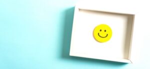 picture of a smiling face in a white box against a blue backdrop