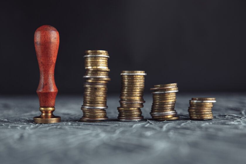 Notary Gavel Over Stacked Golden Coins