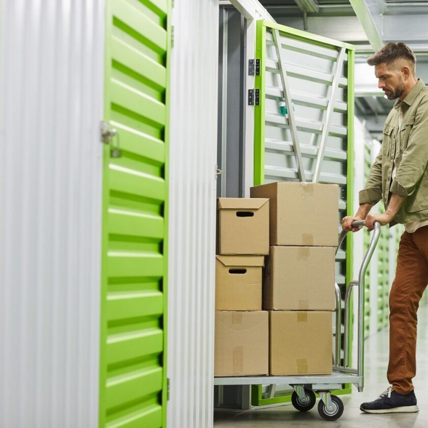man moving storage boxes into a unit