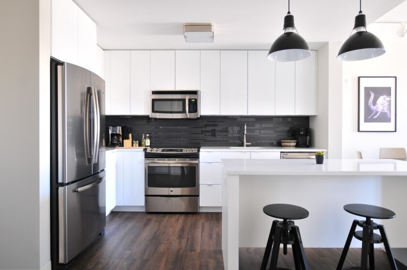 grey steel 3-door fridge inside a modular kitchen