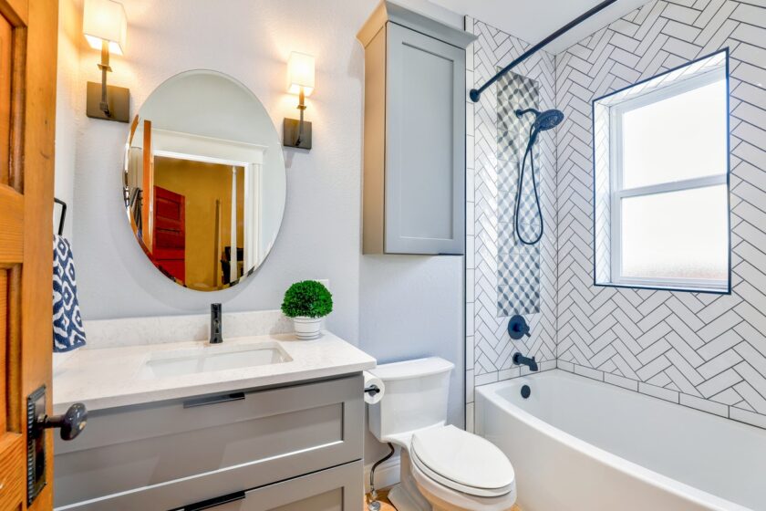 Image of a bathroom with round window and shower of a bathtub