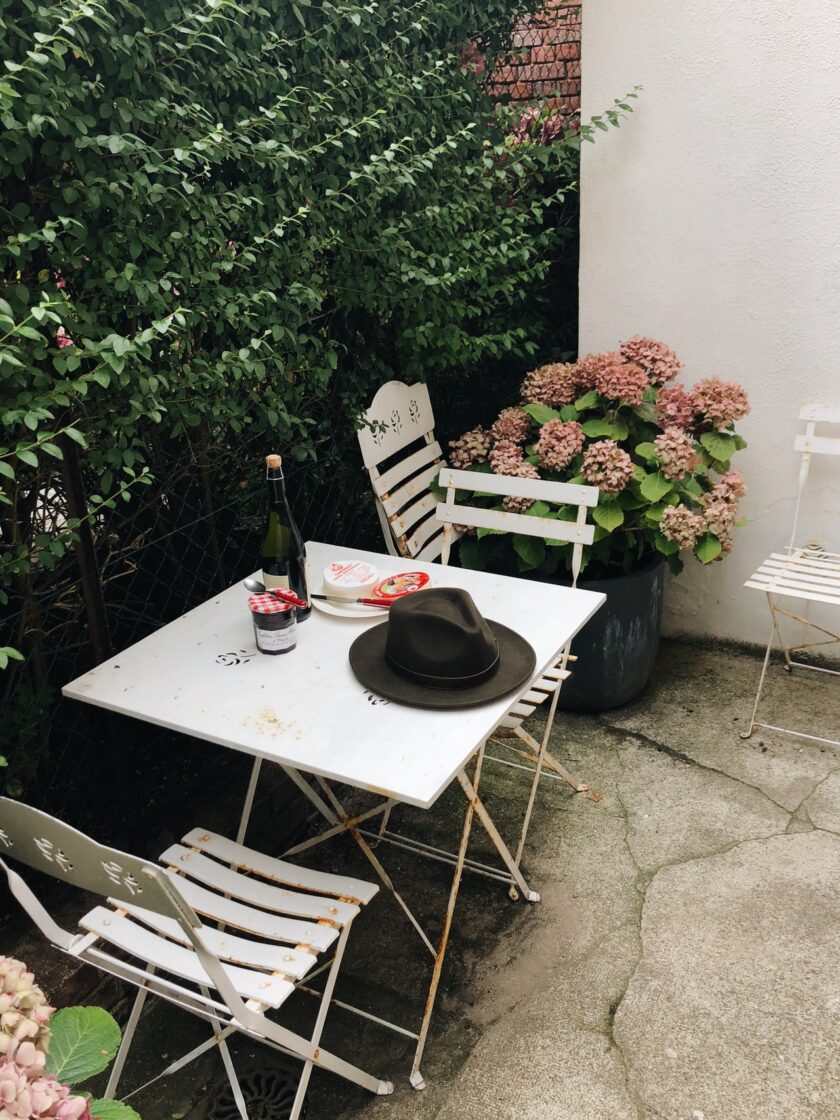 black fedora on top of a garden table