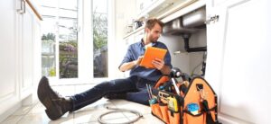 plumber working under a kitchen sink