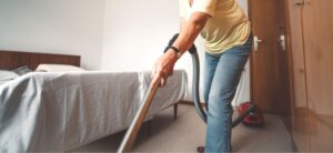 woman cleaning a bedroom area