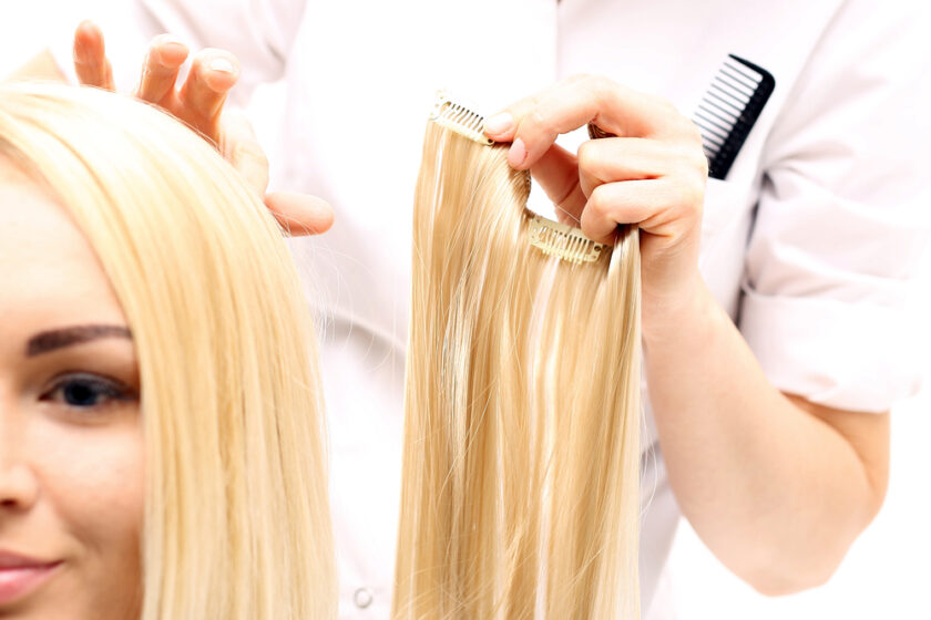 person having blond hair extension added to their hair 