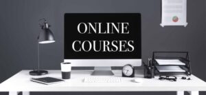 computer screen with online courses on it and study material around it i