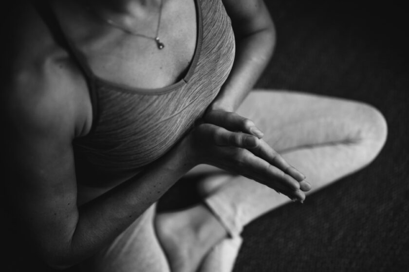 Woman practicing yoga wearing tank top and yoga leggings