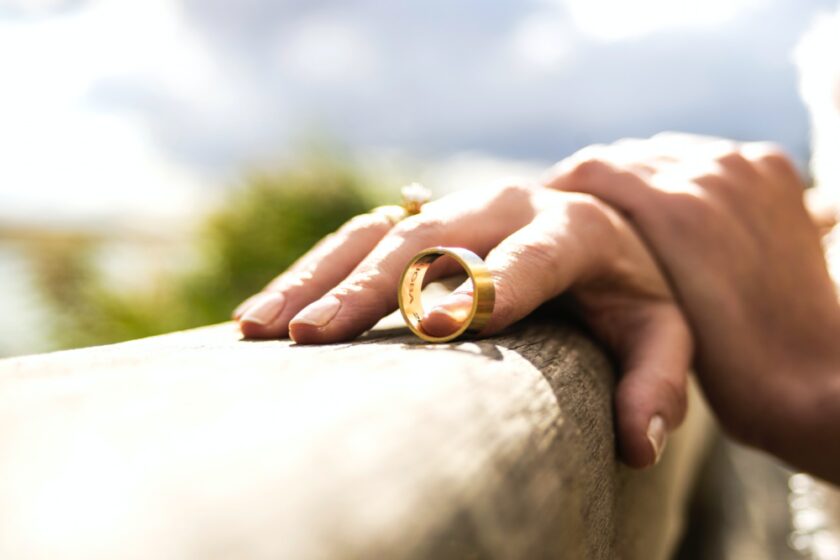 two hands with one partly through a ring