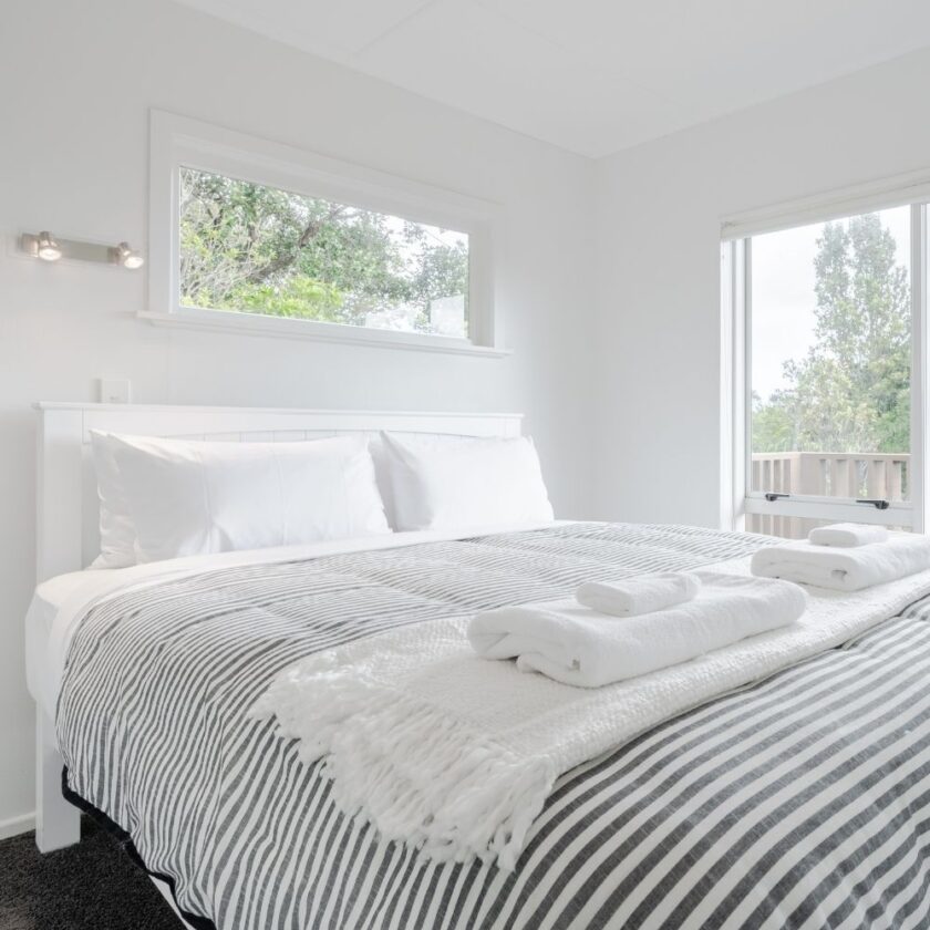modern bright bedroom white walls and stripped bedding