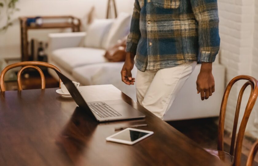 Man stood up near a laptop in a living room