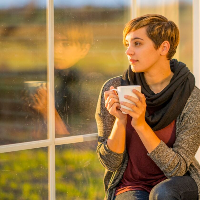 woman relaxing at a window with a cup of tea
