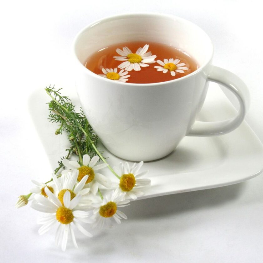 chamomile tea with chamomile flowers beside