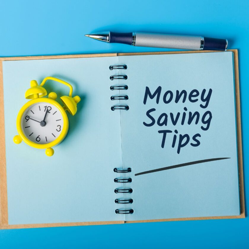 money saving tips written in a notebook next to a pen and a yellow alarm clock 