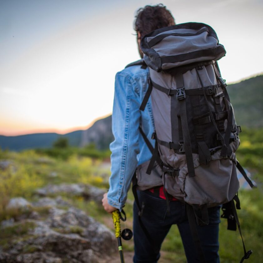 person walking with a large backpack on their back solo travelling 