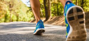 person wearing blue trainers running along a track
