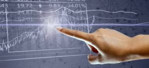 person pointing at a trading graph