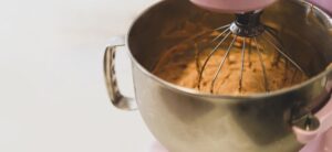 ciose up of a mixer being used in a metallic bowl