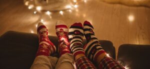 people with their feet up cosy socks on and fairy lights in the background