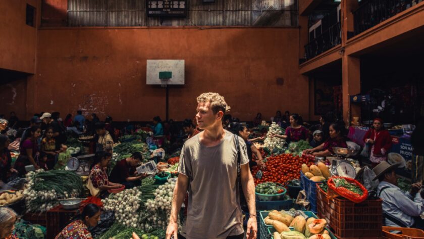 Man in a grey top standing in a market area