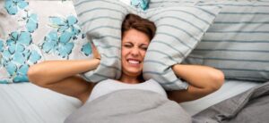 woman struggling to sleep due to noise