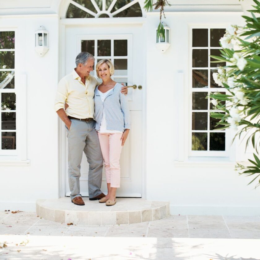 An older couple stood outside their home
