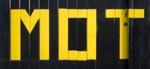 MOT in yellow on a black back ground