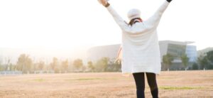 person standing in a field with their arms in the air
