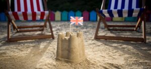 sandcastle on the beach with a union jack flag in it