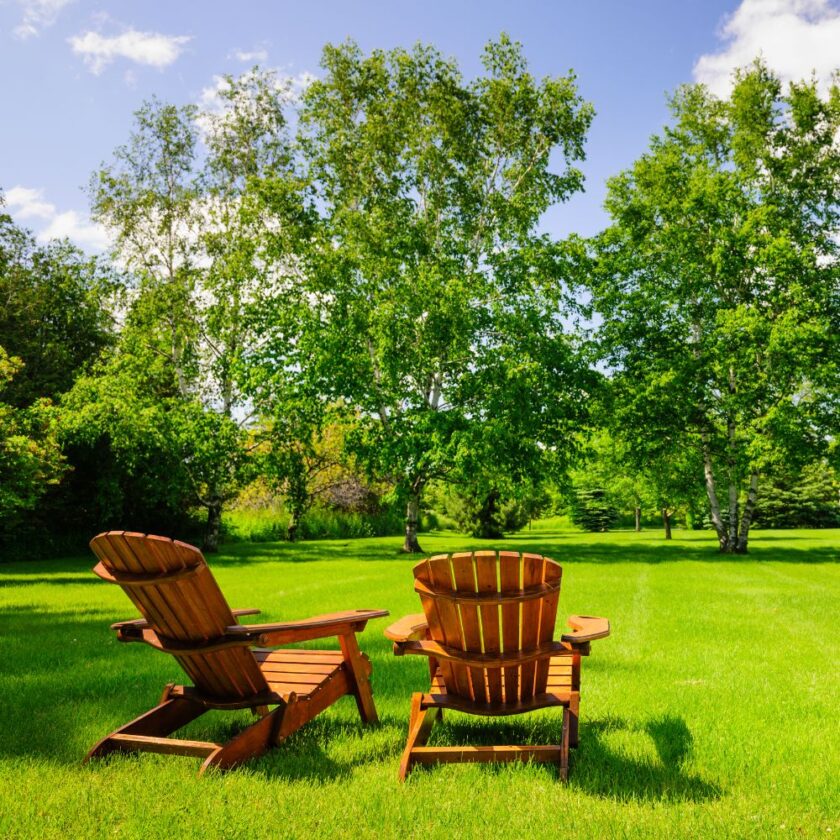 two wooden chairs set up on grass