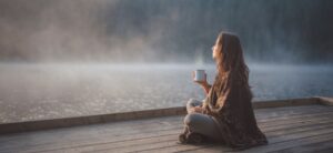 woman relaxing by the edge of a lake
