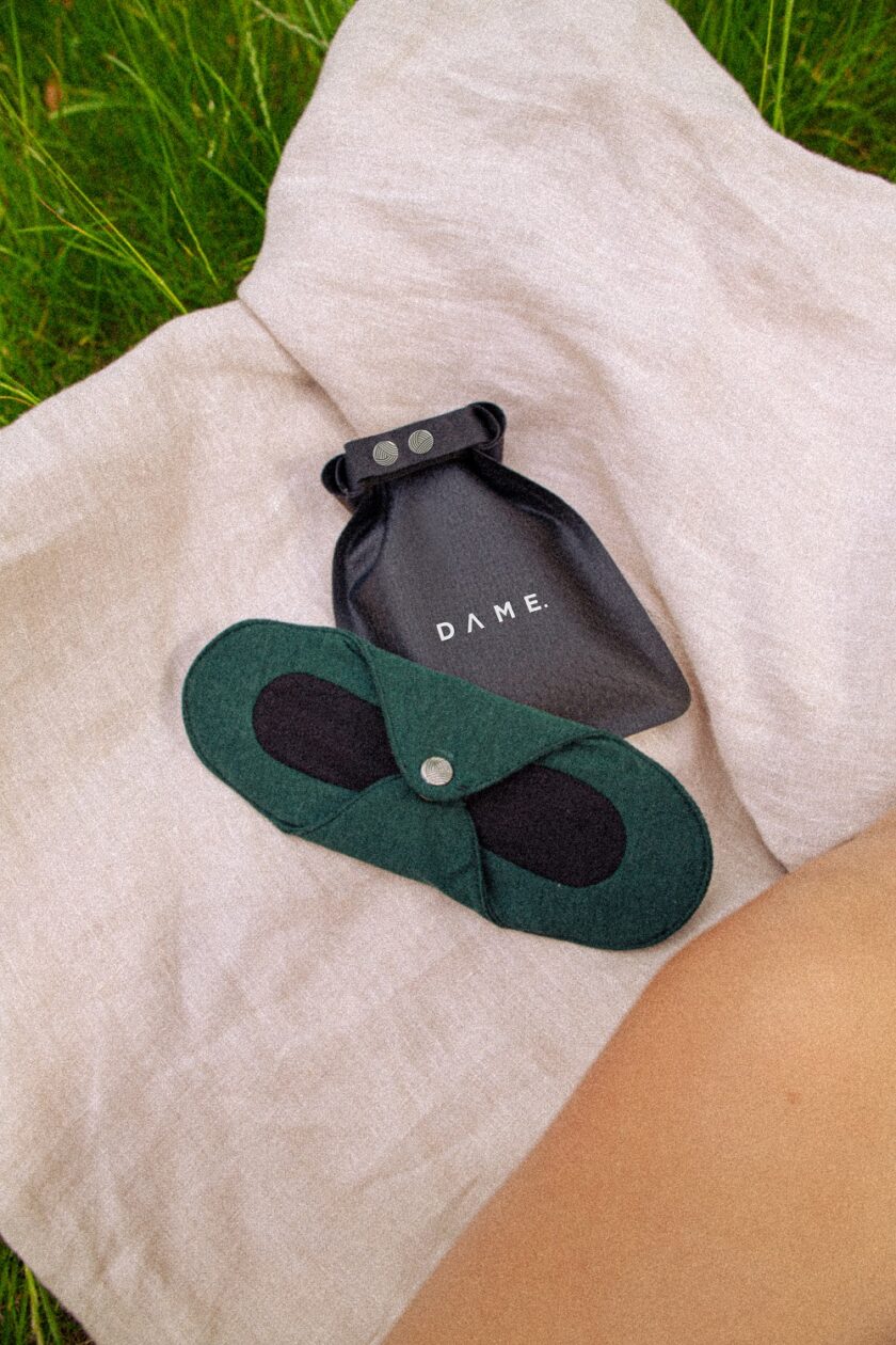 DAME reusable pad and bag placed on a throw