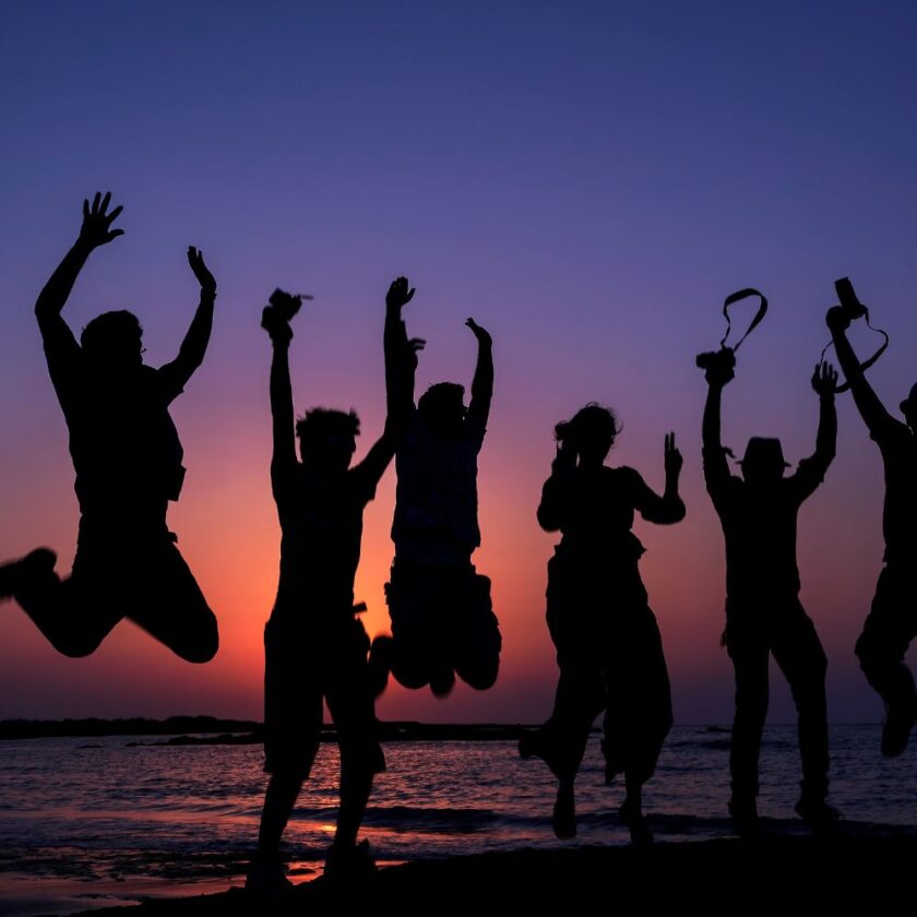 friends jumping with a sunset behind