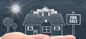 image of a hand holding a house and for sale sign