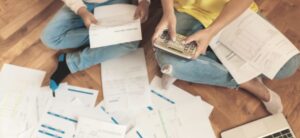 people sat down looking at papers with a calculator